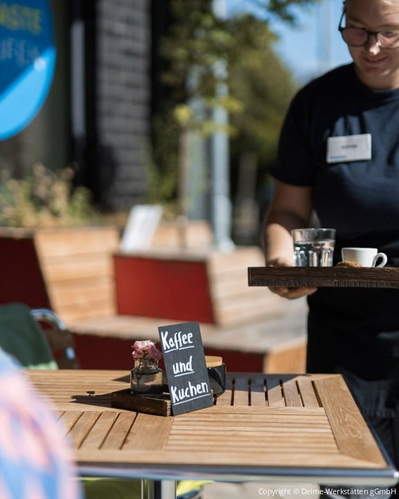 Einem Gast des Unverpacktladens wird draußen ein Kaffee gebracht